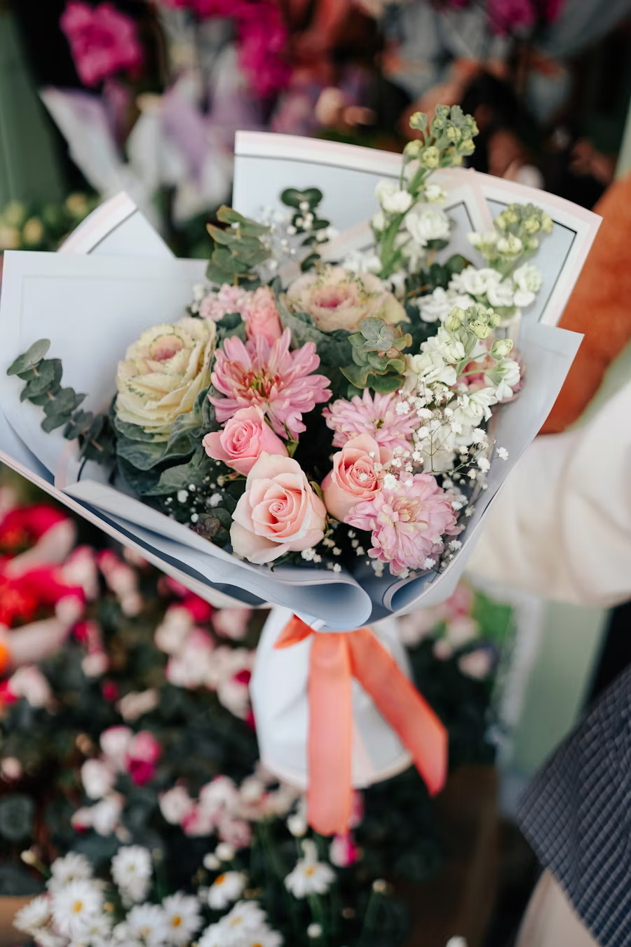 Bouquet de mariée composé de roses crème et rose, chrysanthèmes et eucalyptus, ruban orange